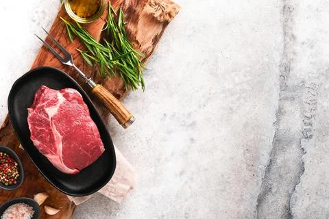 Beef steak. Fresh raw beef rib eye steak with fork rosemary, salt and pepper  Stock Photos