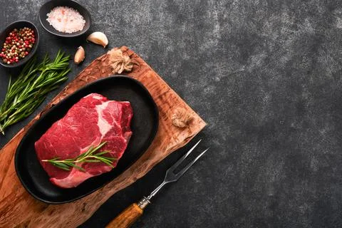 Beef steak. Fresh raw beef rib eye steak with fork rosemary, salt and pepper  Stock Photos
