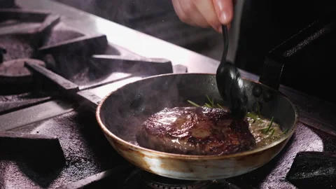 Beef steak fried in butter, chef handling the meat - close-up Stock Footage 152771748