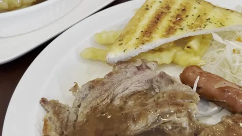 Beef Steak with Fried Egg Sausage and French Fries Stock Footage 342667374