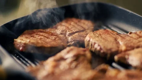 Beef steak fried in pan with steam. selective focus. slow motion Stock Footage