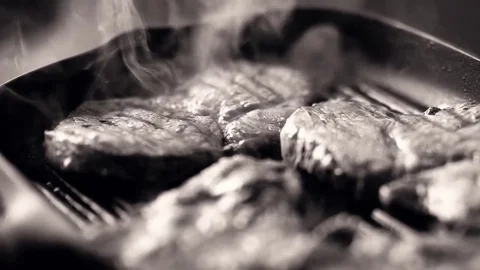 Beef steak fried in pan with steam. selective focus. black and white Video stock 78717816