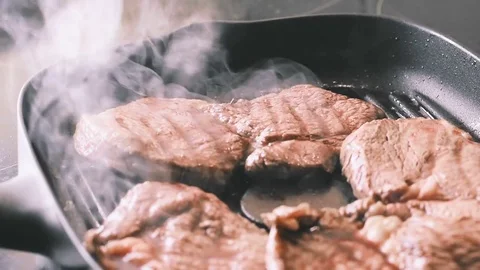 Beef steak fried in pan with steam. selective focus. slow motion Video stock 78805648