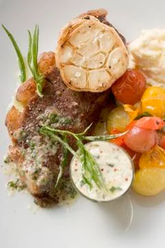 Beef steak with garlic, cherry tomatoes and mustard butter Stock Photos
