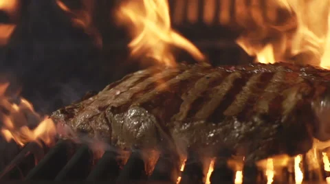 Beef steak on a grill in a fire. Slow motion Stock Footage