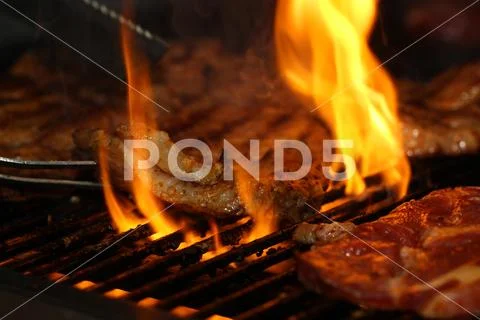 Beef steak on the grill with flames Stock Photos