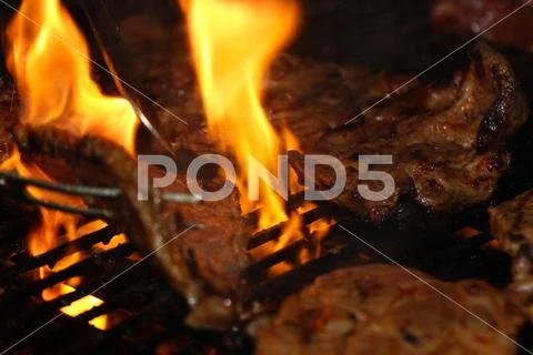 Beef steak on the grill with flames Stock Photos