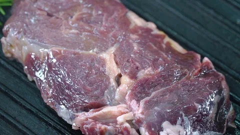 Beef steak on the grill is lifted with forceps and turned over to the other side Stock Footage 75056522