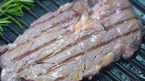 Beef steak on the grill is lifted with forceps and turned over to the other side Stock Footage 75056918