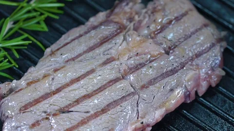 Beef steak on the grill is poured with olive oil. Slow motion Video stock 75056705