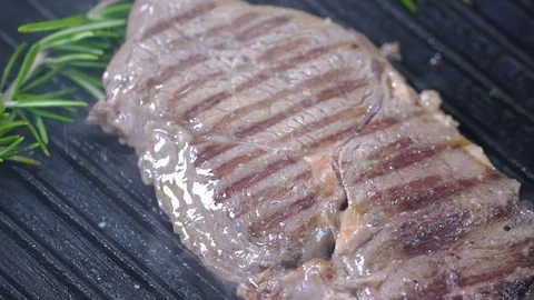 Beef steak on the grill is sprinkled with salt. Slow motion Stock Footage 75238512