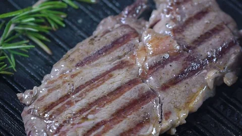 Beef steak on the grill is sprinkled with salt. Slow motion Stock Footage 75238931