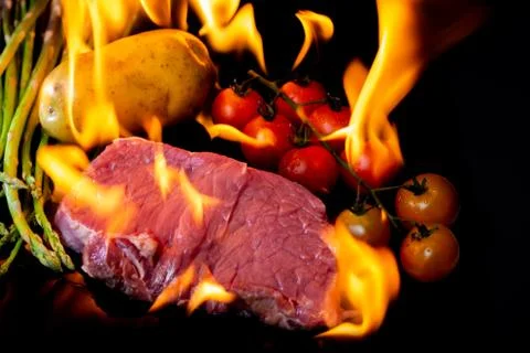 Beef steak grilling on back background Stock Photos