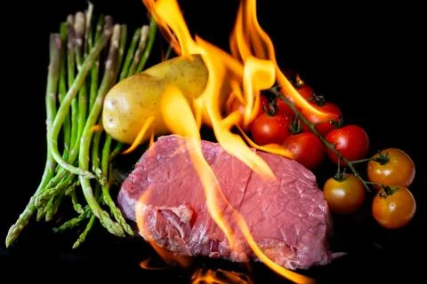 Beef steak grilling on back background Stock Photos