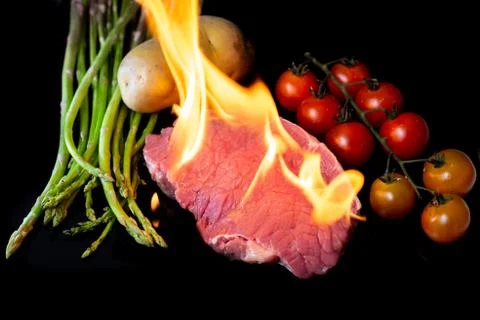 Beef steak grilling on back background Stock Photos