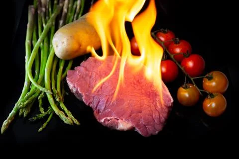 Beef steak grilling on back background Stock Photos