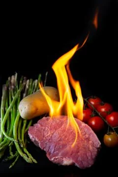 Beef steak grilling on back background Foto stock