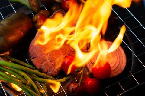 Beef steak grilling on back background Stock Photos