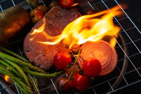 Beef steak grilling on back background Stock Photos