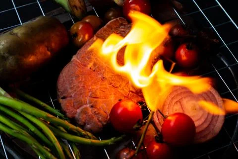 Beef steak grilling on back background Stock Photos