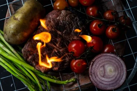 Beef steak grilling on back background Stock Photos