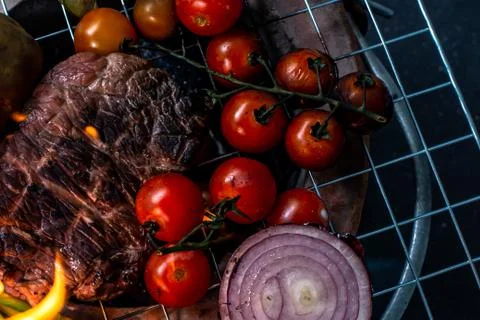 Beef steak grilling on back background Stock Photos