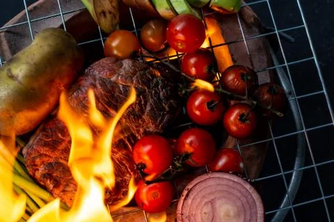 Beef steak grilling on back background Stock Photos