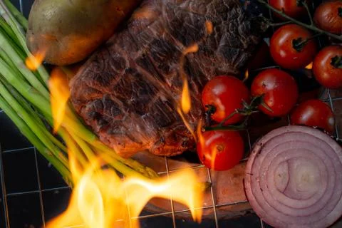 Beef steak grilling on back background Stock Photos