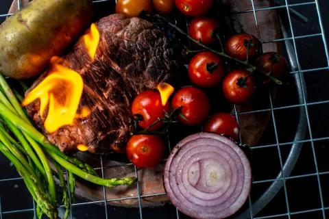 Beef steak grilling on back background Stock Photos