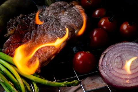 Beef steak grilling on back background Stock Photos
