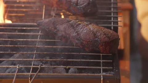 Beef Steak Grilling Over Charcoal Embers On Metal Grate With Rising Smoke Stock Footage 343892616