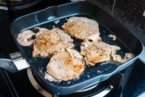 Beef steak grilling in a pan in the kitchen. Select focus Foto stock