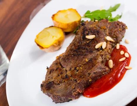 Beef steak with ketchup and pine nuts, served with potatoe Stock Photos