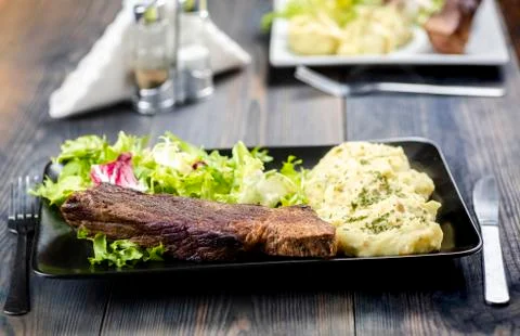 Beef steak with mashed potatoes and rocket salad Foto stock