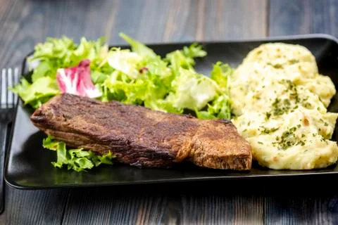 Beef steak with mashed potatoes and rocket salad Stock Photos