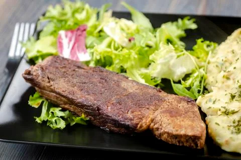 Beef steak with mashed potatoes and rocket salad Stock Photos