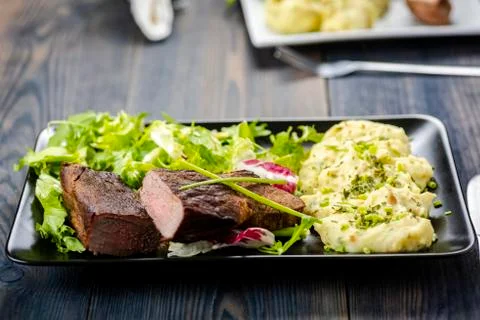 Beef steak with mashed potatoes and rocket salad Stock Photos