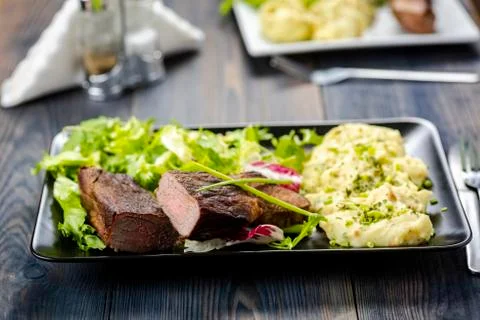 Beef steak with mashed potatoes and rocket salad Stock Photos