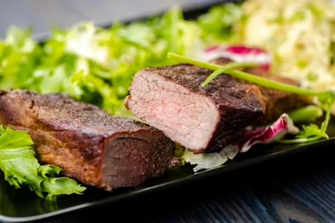 Beef steak with mashed potatoes and rocket salad Stock Photos