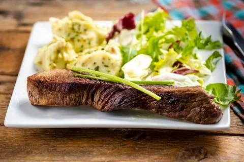 Beef steak with mashed potatoes and rocket salad Foto stock