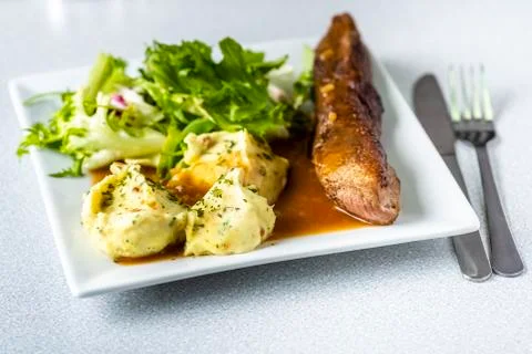 Beef steak with mashed potatoes and rocket salad Stock Photos
