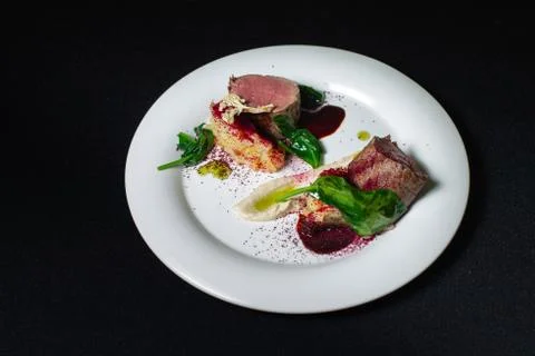 Beef steak with mashed potatoes decorated with greens on a white plate. Photos