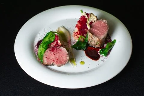 Beef steak with mashed potatoes decorated with greens on a white plate. Stock Photos