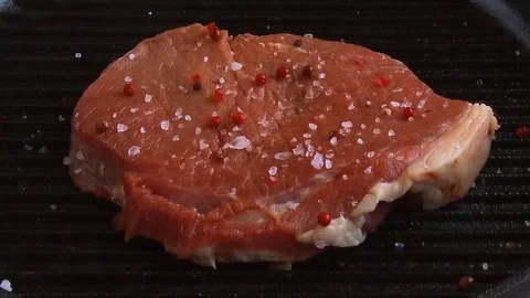 Beef steak meat grilled in a frying pan sprinkled with spices Video stock 77307285