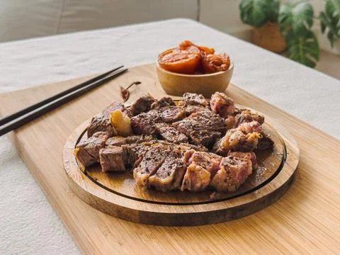 Beef steak medium rare with tomato on wooden plate. Foto stock