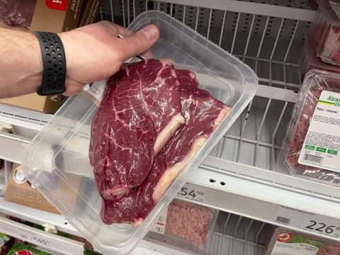 Beef steak in a package. A man's hand holds a package with beef meat in a store. Stock Photos