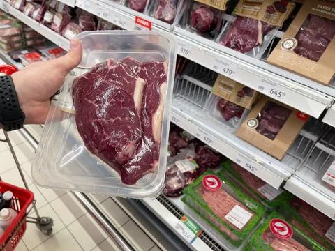 Beef steak in plastic packaging. A customer is choosing beef meat. Stock Photos