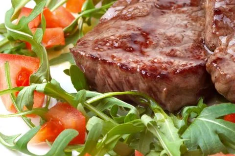 Beef steak with rocket salad Stock Photos