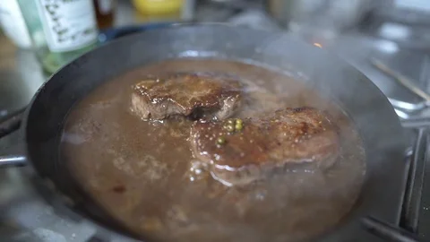 Beef steak searing in fresh pepper sauce in pan in kitchen Stock Footage 128570840