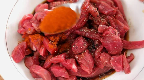 Beef steak slices marinating - spicing with ground chili pepper Stock Footage 35935352